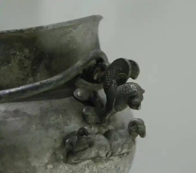 A winged lion on top of two rams A winged lion on top of two rams